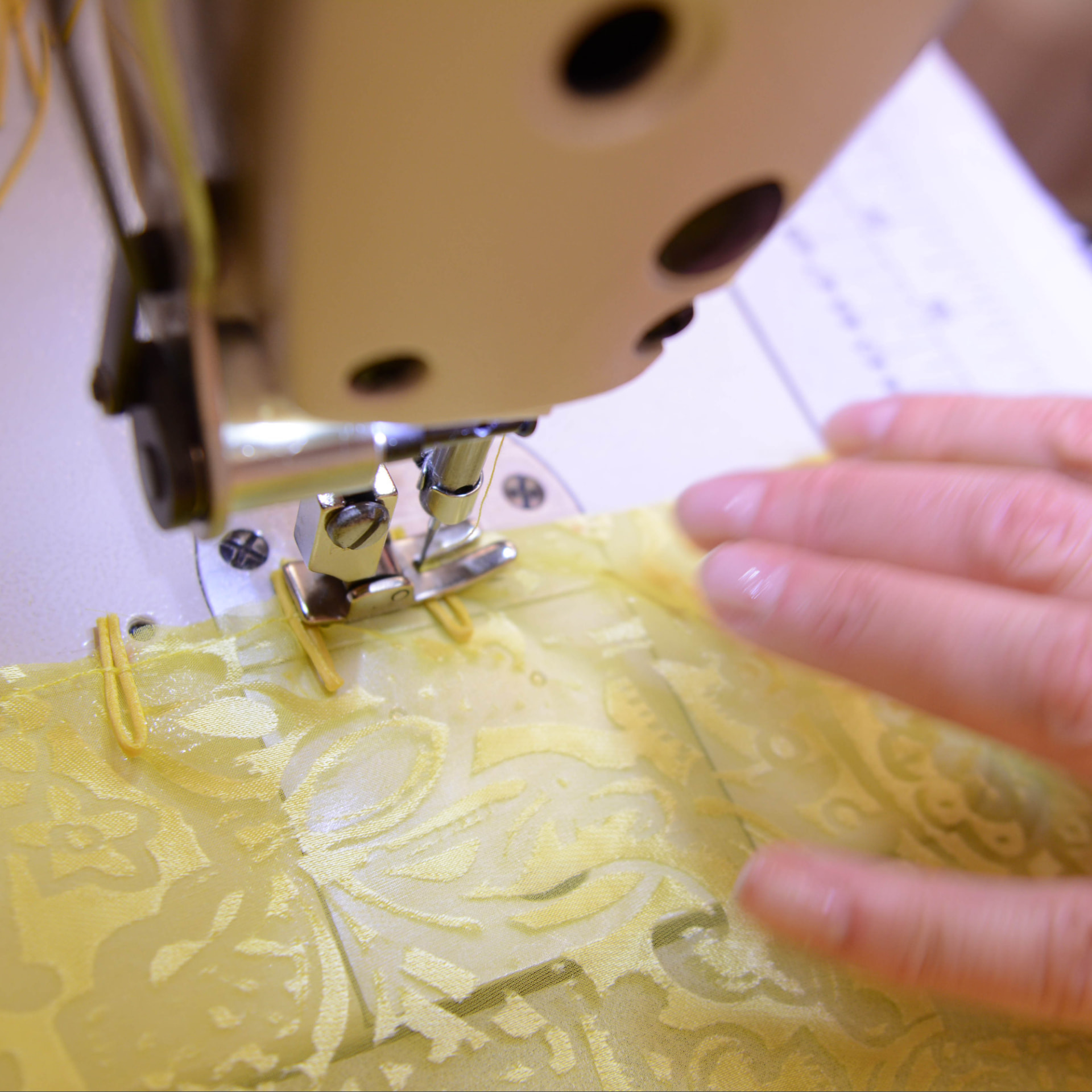 Yellow devore organza stitched under an industrial machine foot